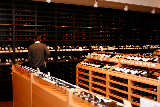 Wine-Store: Man Browsing Racks of Wine Bottles