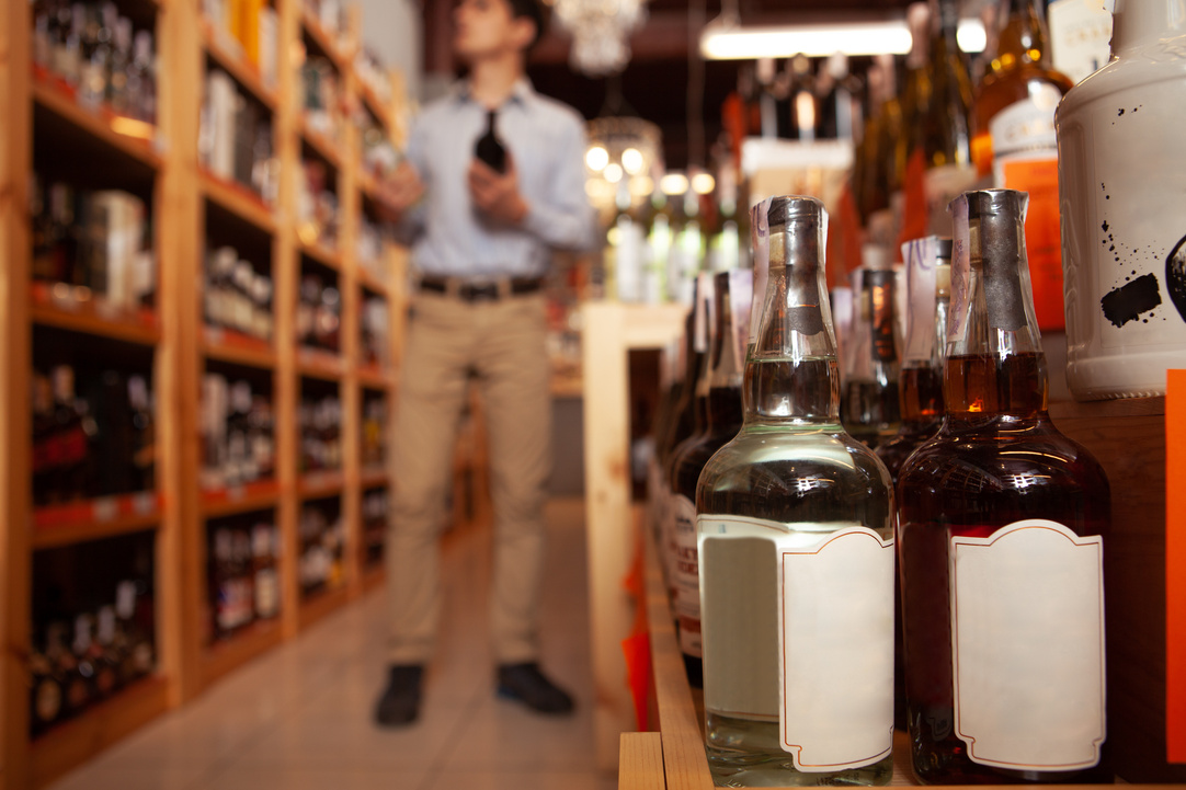 Handsome man shopping for alcohol at liquor store
